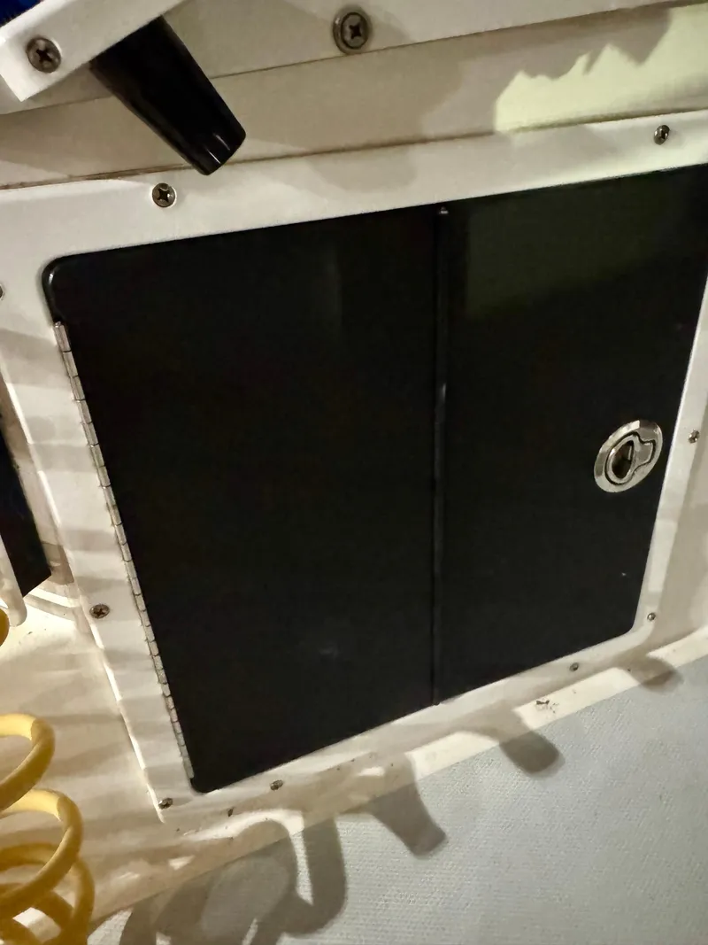 Slide: The Image of 1998 Regulator 26 Express boat compartment with black door and lock. - 20