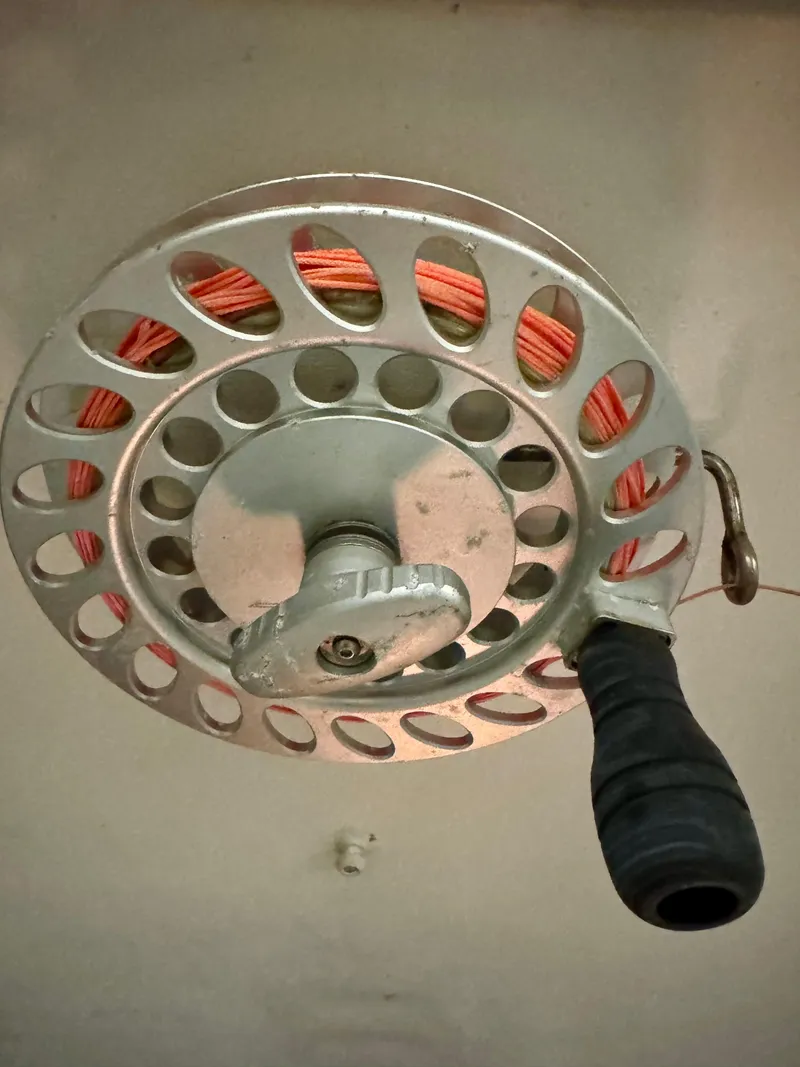 Slide: The Image of Fishing reel with orange line and black handle, mounted on a Regulator 26 Express boat. - 22