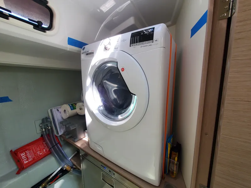 Slide: The Image of Washing machine inside 2023 Hanse 460 yacht, compact laundry area with storage. - 34