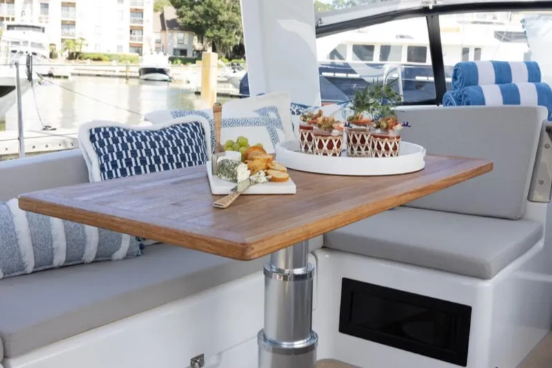 Slide: The Image of 2023 Hanse 460 yacht interior with elegant dining setup on wooden table. - 36