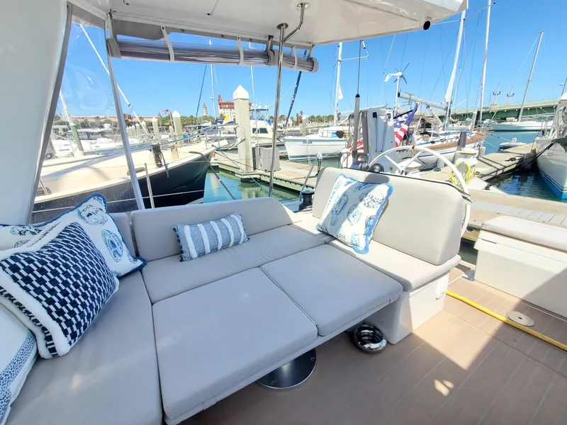 Slide: The Image of 2023 Hanse 460 yacht with comfortable outdoor seating at a marina. - 43