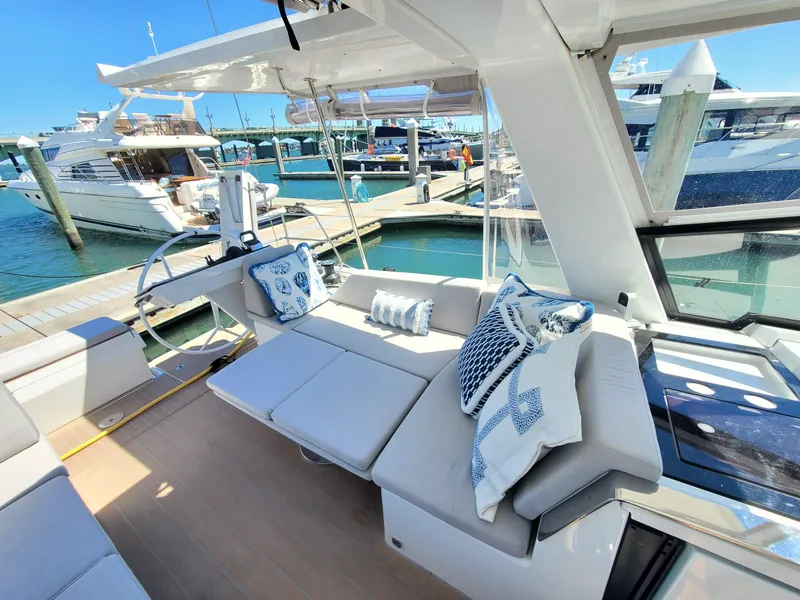 Slide: The Image of Luxurious 2023 Hanse 460 yacht interior with plush seating and nautical-themed cushions at a marina. - 44