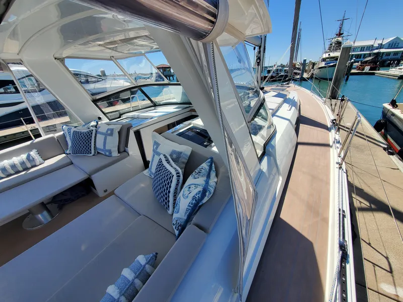 Slide: The Image of Luxurious 2023 Hanse 460 yacht with elegant seating and nautical-themed cushions at a marina. - 46