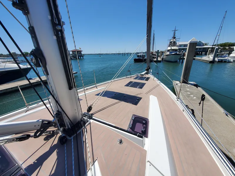Slide: The Image of 2023 Hanse 460 yacht docked at marina, showcasing sleek deck design and ocean view. - 47