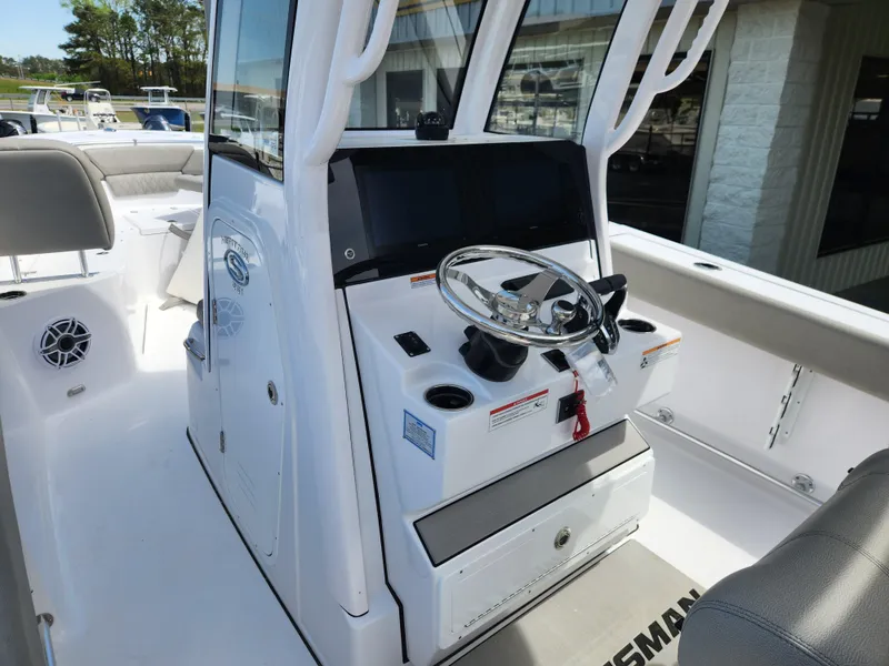 Slide: The Image of 2025 Sportsman Heritage 261 Center Console boat interior with steering wheel and seating. - 13
