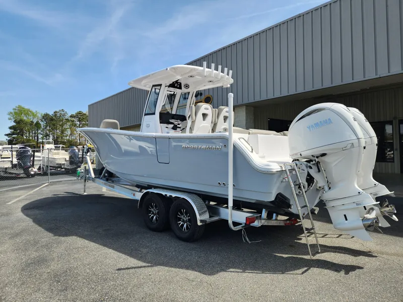 Slide: The Image of 2025 Sportsman Heritage 261 Center Console boat on trailer, parked outdoors. - 2