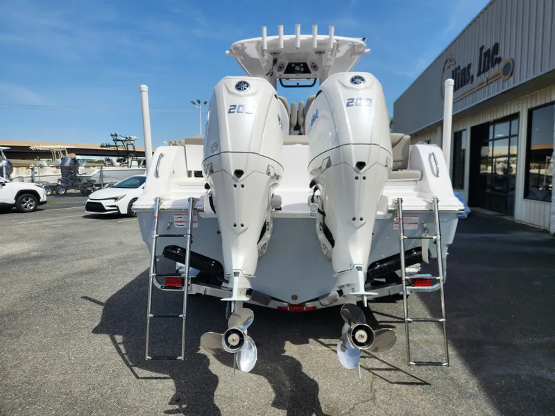 Slide: The Image of 2025 Sportsman Heritage 261 Center Console with dual outboard engines, parked outdoors. - 3