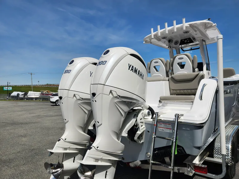 Slide: The Image of 2025 Sportsman Heritage 261 Center Console with twin Yamaha engines, parked outdoors. - 4