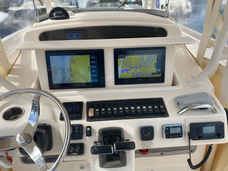 Slide: The Image of 2016 Grady-White Canyon boat dashboard with navigation screens and controls. - 10