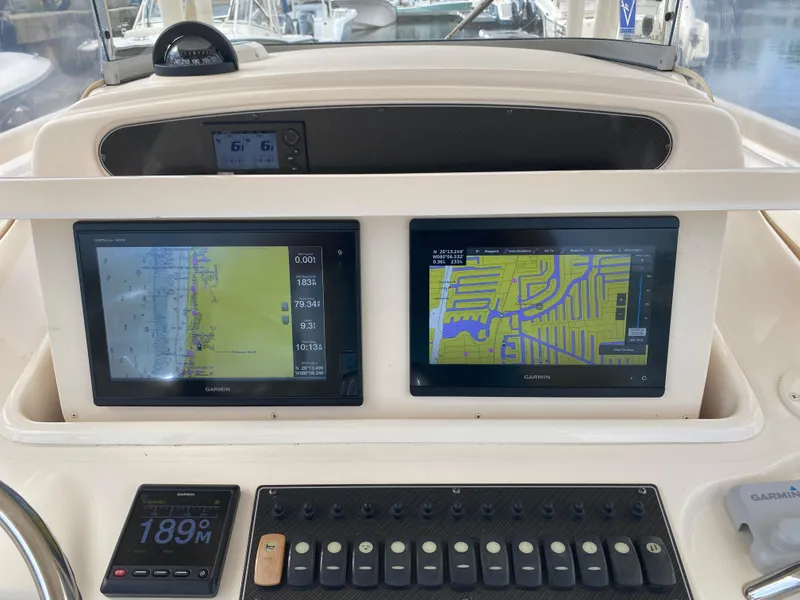 Slide: The Image of 2016 Grady-White Canyon boat dashboard with dual Garmin navigation screens. - 12