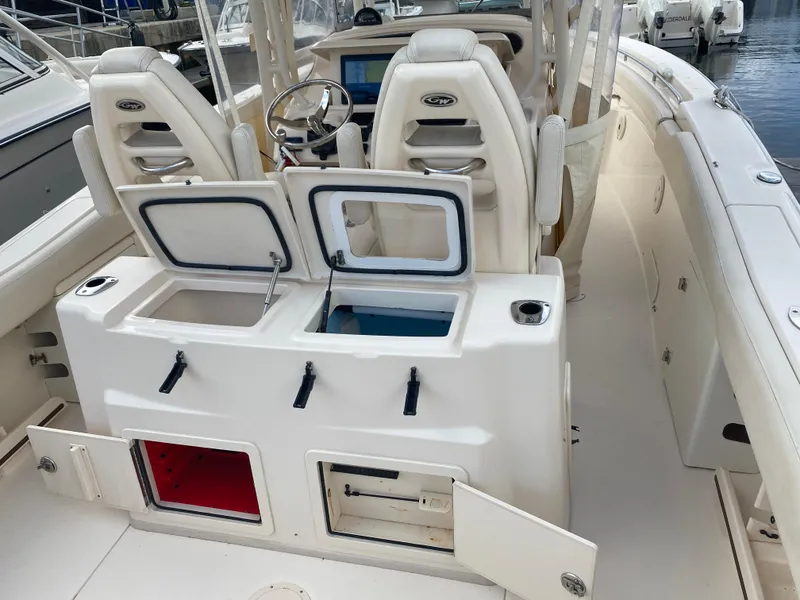 Slide: The Image of 2016 Grady-White Canyon boat interior with open storage compartments and helm seating. - 14