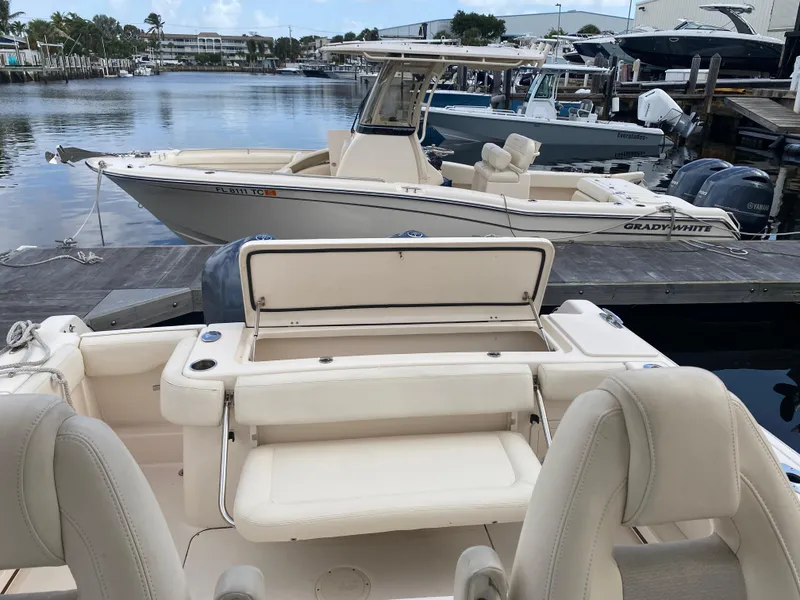 Slide: The Image of 2016 Grady-White Canyon boat docked at marina, showcasing sleek design and spacious seating. - 15