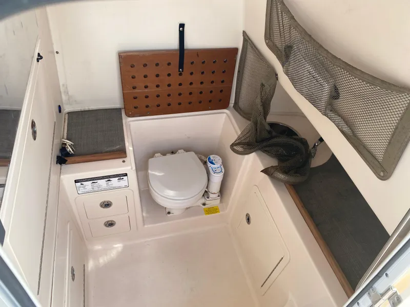 Slide: The Image of 2016 Grady-White Canyon boat interior with toilet and storage compartments. - 16
