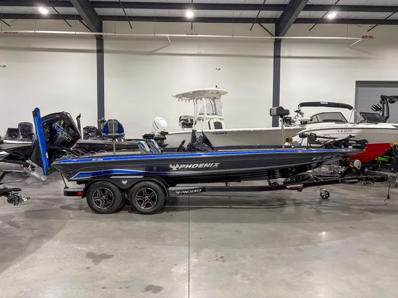 Slide: The Image of 2020 Phoenix 921 ELITE bass boat in showroom, sleek design, black and blue color scheme. - 1