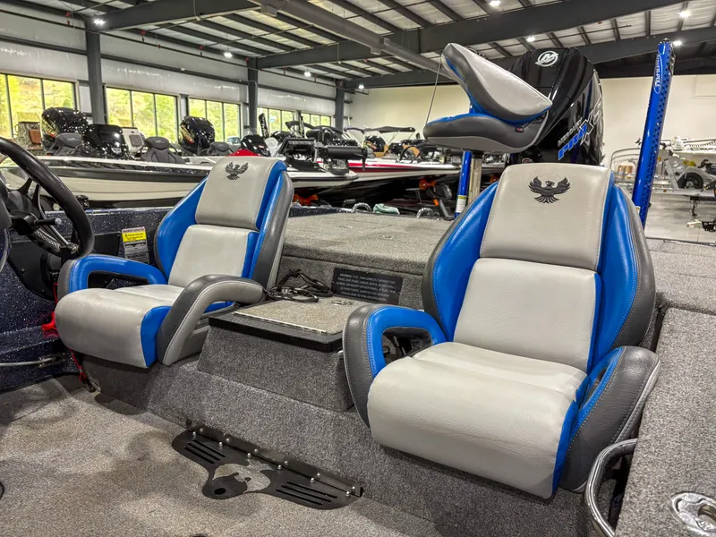 Slide: The Image of 2020 Phoenix 921 ELITE boat interior with blue and gray seats in a showroom. - 13