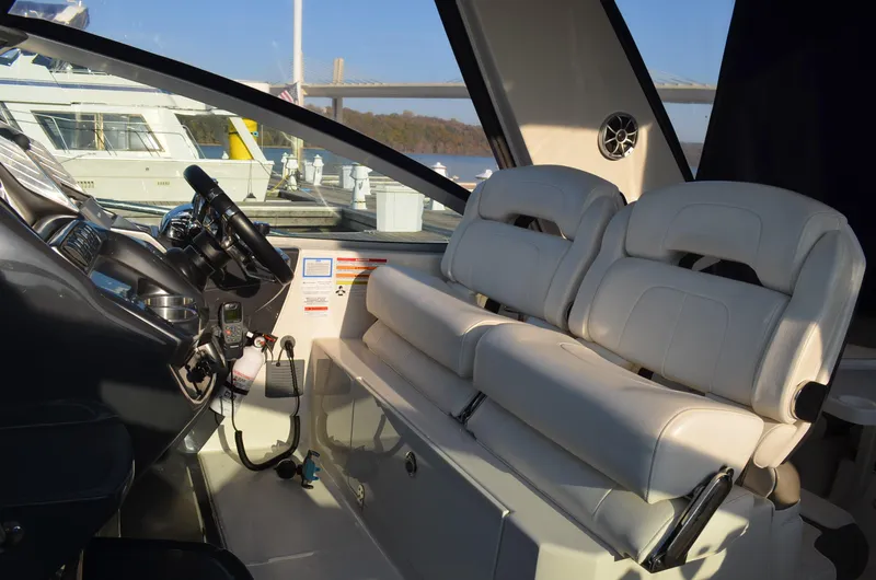 Slide: The Image of 2013 Monterey 340 SY boat interior with white leather seats and control panel. - 14
