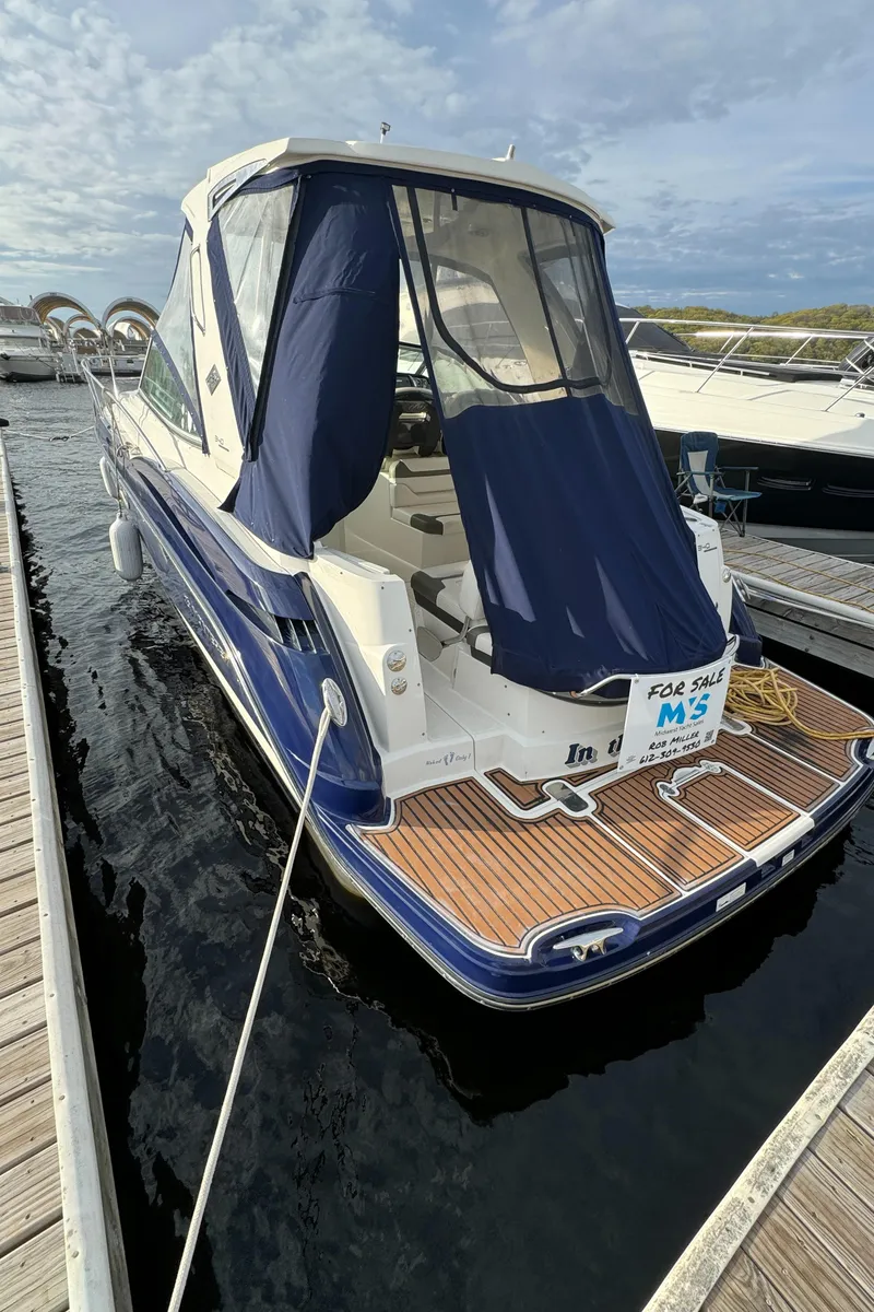 Slide: The Image of 2013 Monterey 340 SY boat docked with blue canopy and wooden deck. - 2