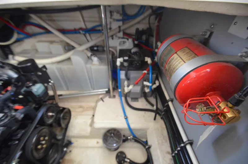 Slide: The Image of Engine compartment of a 2013 Monterey 340 SY boat, featuring mechanical components and fire extinguisher. - 22