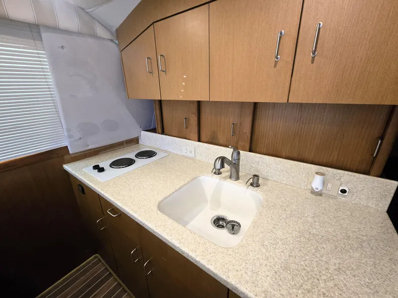 Slide: The Image of 2001 Ocean Yachts 43 Super Sport kitchen with sink, stove, and wooden cabinets. - 13