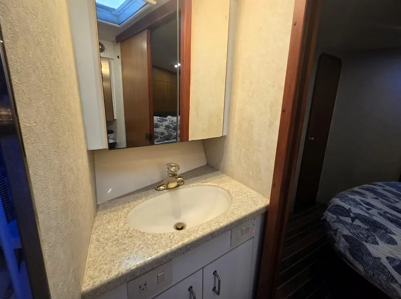 Slide: The Image of Bathroom vanity in 2001 Ocean Yachts 43 Super Sport, featuring a sink and mirror. - 22