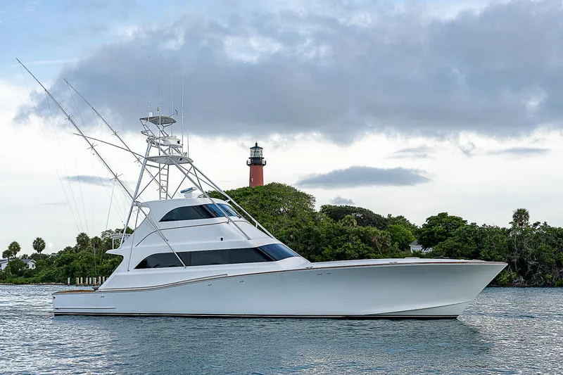 Slide: The Image of 2001 American Custom Enclosed Flybridge yacht on water with lighthouse in background. - 1