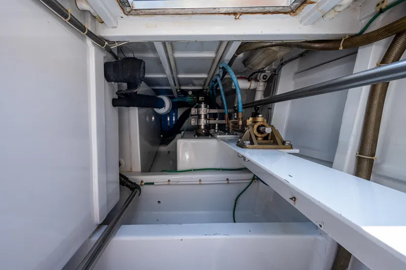 Slide: The Image of 2001 American Custom Enclosed Flybridge engine room with visible pipes and mechanical components. - 18