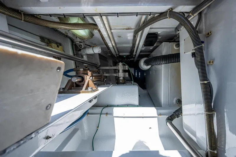 Slide: The Image of Engine room of a 2001 American Custom Enclosed Flybridge boat, showcasing mechanical components. - 19