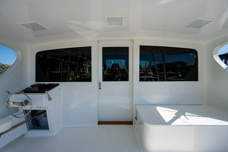 Slide: The Image of 2001 American Custom Enclosed Flybridge interior with helm station and seating area. - 26