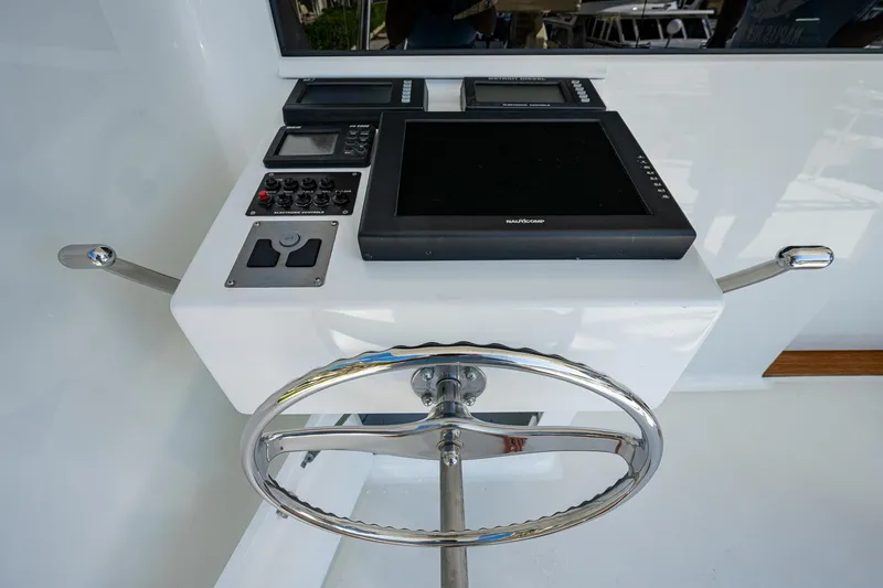 Slide: The Image of Steering console of a 2001 American Custom Enclosed Flybridge yacht with navigation equipment. - 28