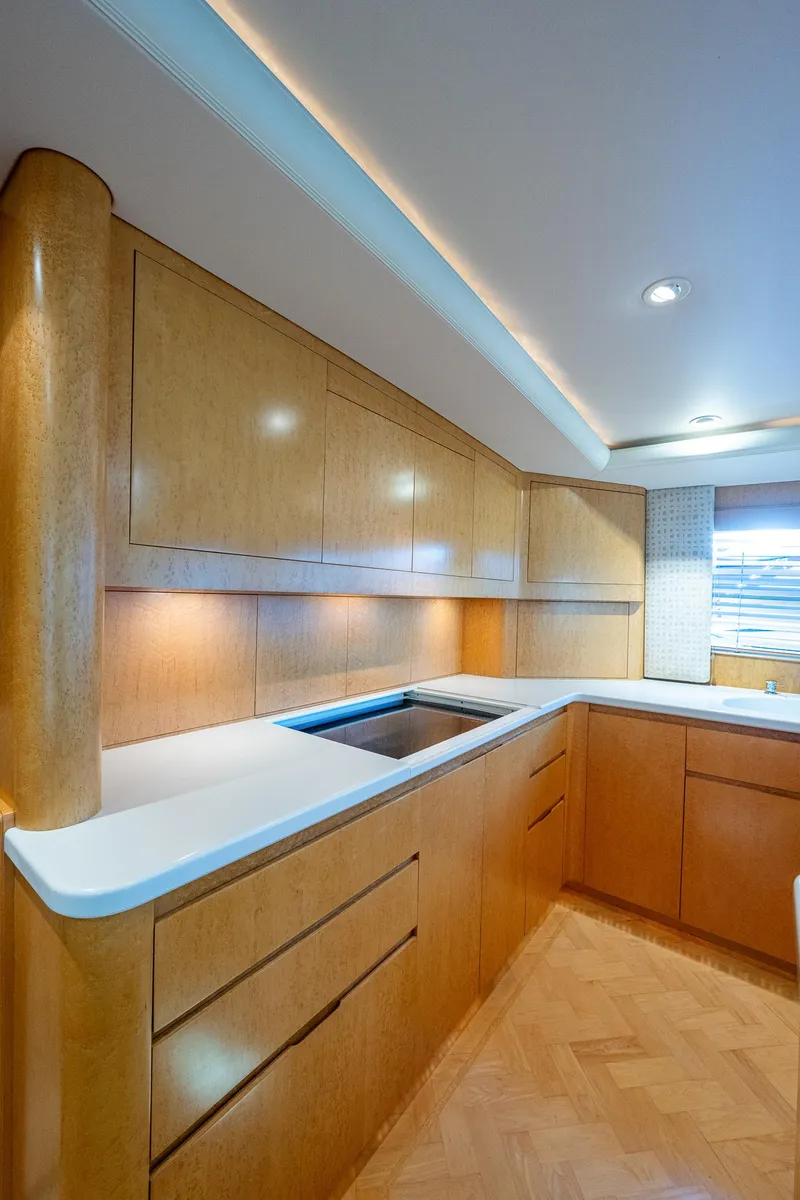 Slide: The Image of 2001 American Custom Enclosed Flybridge kitchen with wood cabinetry and modern lighting. - 38