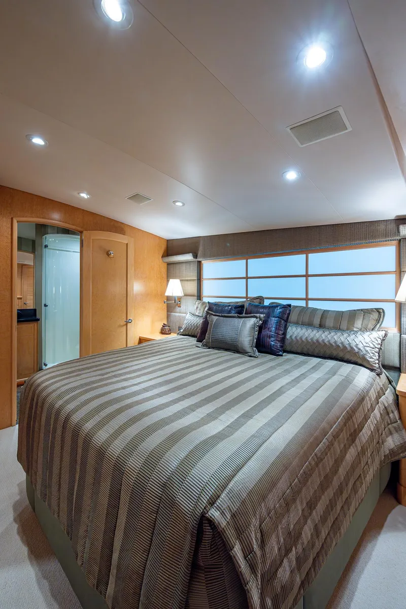 Slide: The Image of Luxurious bedroom in 2001 American Custom Enclosed Flybridge yacht with elegant decor and ambient lighting. - 48