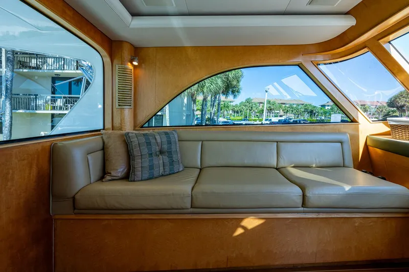 Slide: The Image of Luxurious interior of 2001 American Custom Enclosed Flybridge with beige seating and scenic windows. - 9