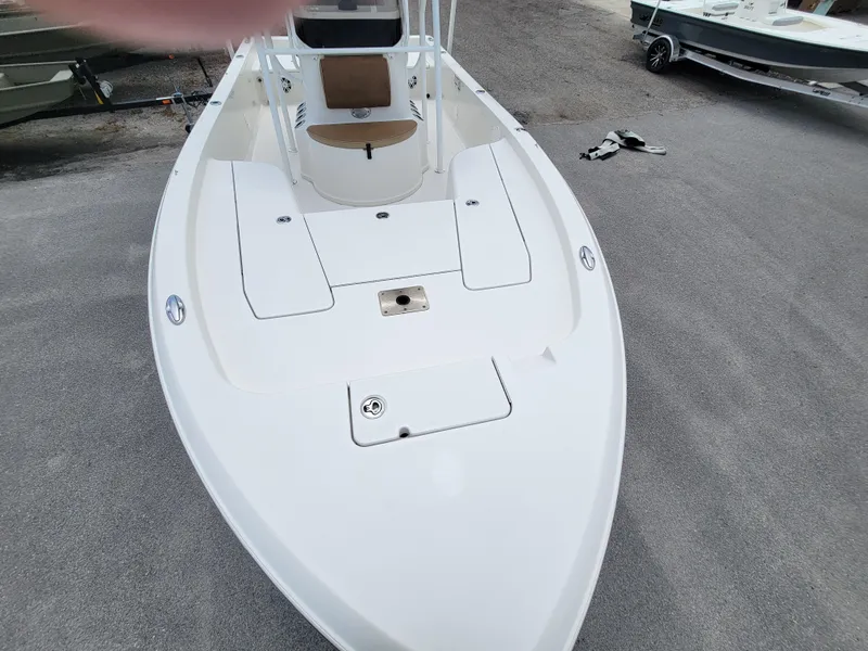 Slide: The Image of 2016 Ranger 220 Bahia boat, white deck, spacious seating, parked on concrete surface. - 13