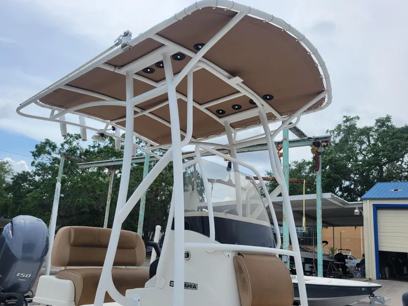 Slide: The Image of 2016 Ranger 220 Bahia boat with canopy and seating, parked outdoors. - 15