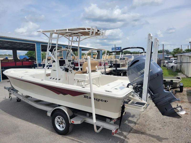 Slide: The Image of 2016 Ranger 220 Bahia boat with Yamaha outboard motor on trailer, parked outdoors. - 6