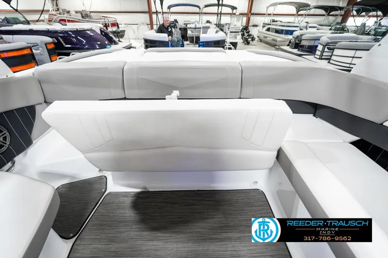 Slide: The Image of 2021 Four Winns H260 boat interior with sleek seating and modern design in a showroom. - 32