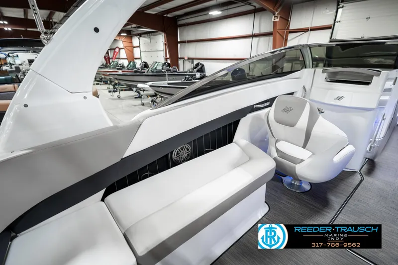 Slide: The Image of 2021 Four Winns H260 boat interior with seating, displayed in a showroom. - 33