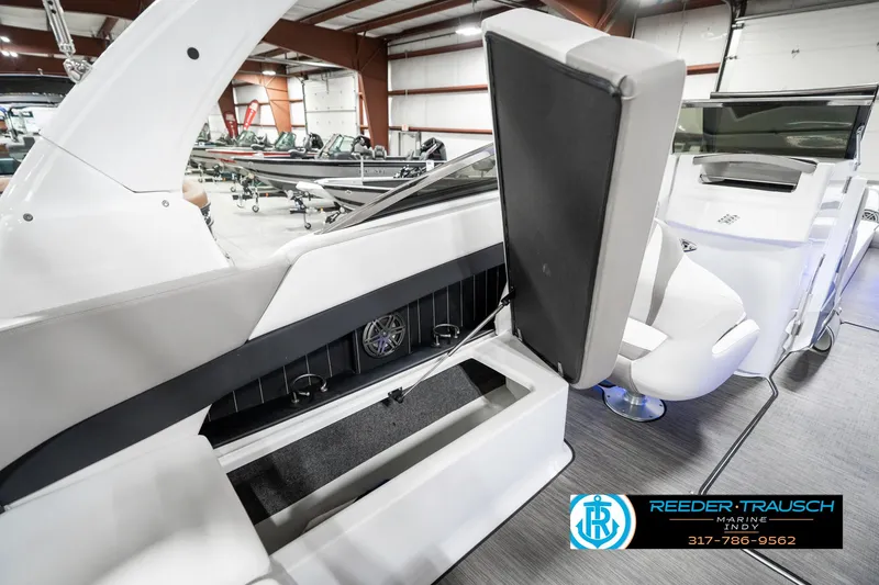 Slide: The Image of 2021 Four Winns H260 boat interior with seating and storage in a showroom. - 34