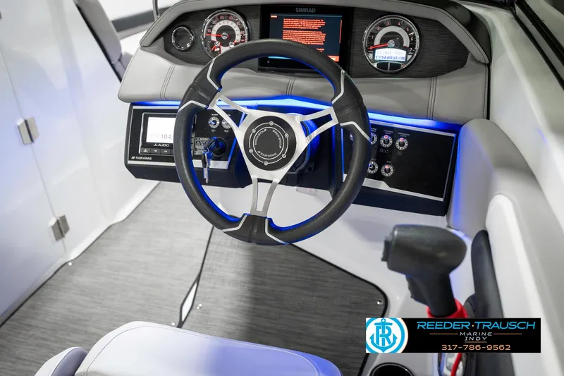 Slide: The Image of 2021 Four Winns H260 boat dashboard with illuminated controls and steering wheel. - 39