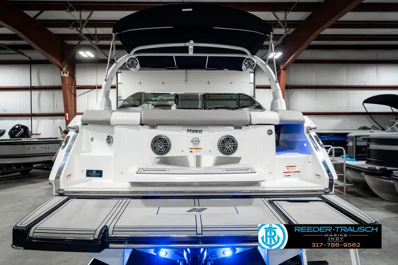 Slide: The Image of 2021 Four Winns H260 boat in showroom, rear view with swim platform and speakers. - 9