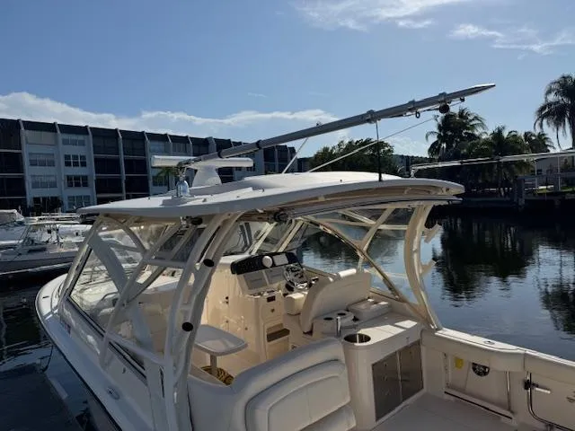 Slide: The Image of 2021 Grady-White Freedom 335 boat docked near waterfront buildings and palm trees. - 10