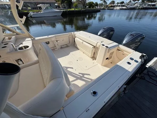 Slide: The Image of 2021 Grady-White Freedom 335 boat interior with dual outboard motors, docked by calm waters. - 11