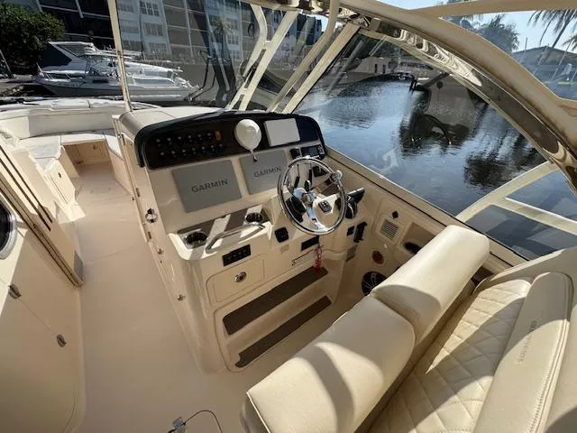 Slide: The Image of 2021 Grady-White Freedom 335 boat interior with Garmin navigation, steering wheel, and seating. - 19