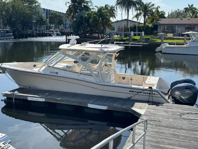 Slide: The Image of 2021 Grady-White Freedom 335 boat docked in a serene marina setting. - 2