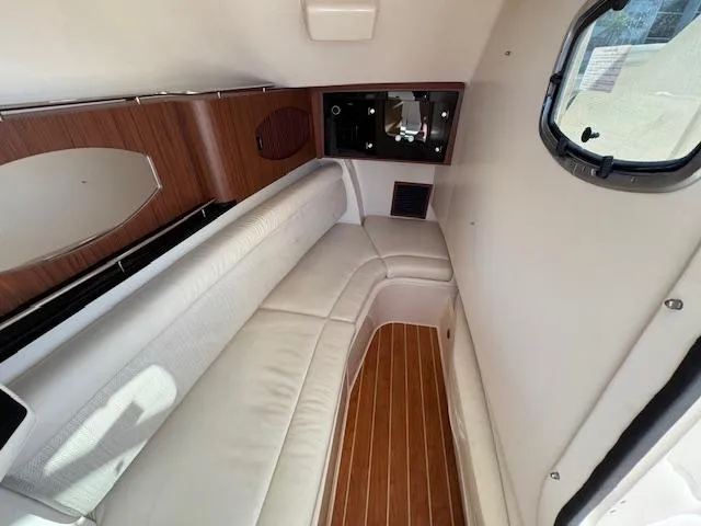 Slide: The Image of 2021 Grady-White Freedom 335 cabin interior with white seating and wood accents. - 21