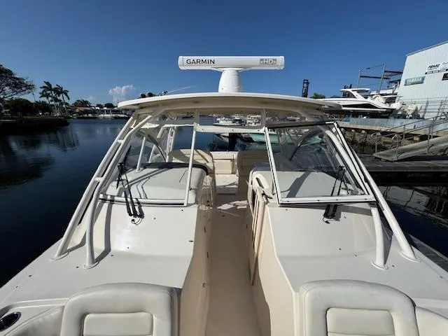 Slide: The Image of 2021 Grady-White Freedom 335 boat docked, featuring Garmin radar, clear skies, and calm waters. - 25