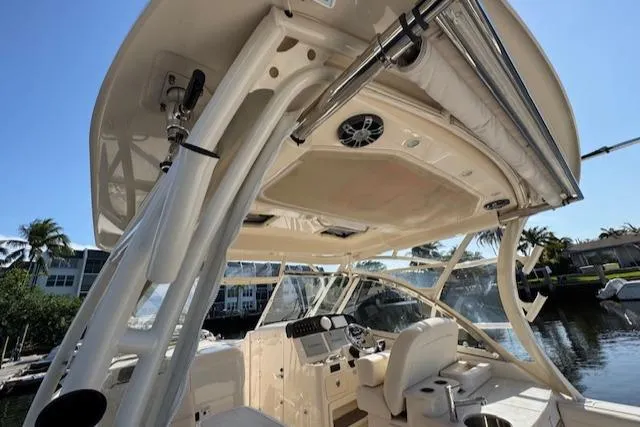 Slide: The Image of 2021 Grady-White Freedom 335 boat interior with helm, seating, and canopy in a marina setting. - 36