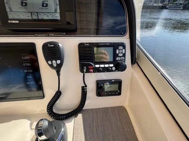 Slide: The Image of 2021 Grady-White Freedom 335 boat dashboard with Icom radio and control panel. - 39