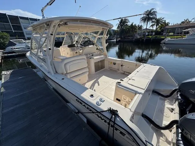 Slide: The Image of 2021 Grady-White Freedom 335 boat docked by a serene waterfront. - 4