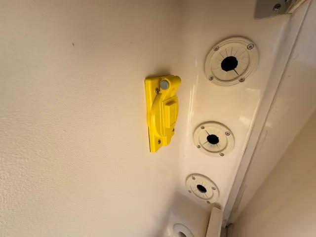 Slide: The Image of Yellow latch and circular mounts on 2021 Grady-White Freedom 335 boat interior. - 48
